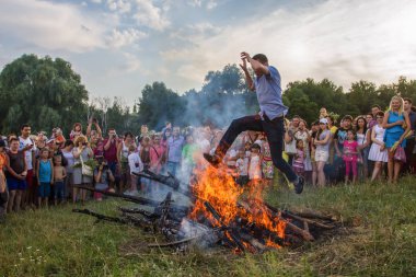 People participate in the celebration on the Ivan Kupala holiday at the National architecture and household museum in the village of Pirogovo in Kiev, Ukraine. July 7, 2013. clipart