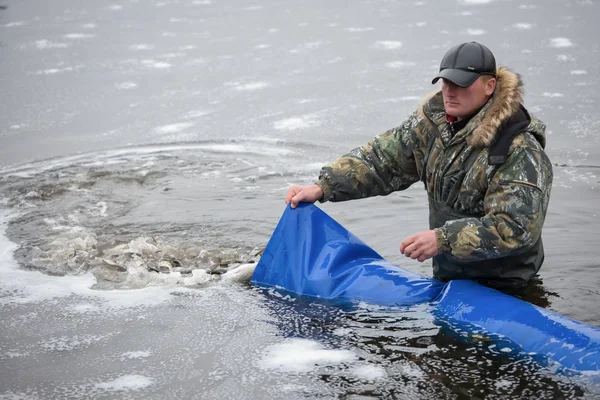 Environmental agency employee produces artificially grown fish in Kiev reservoir in Kiev region, Ukraine. — ストック写真