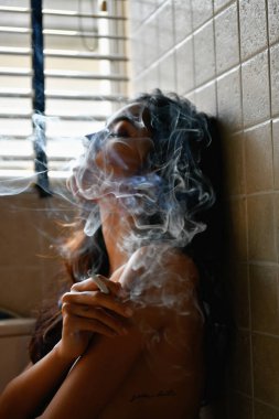 Sigara kavramı. Seksi kadın odaya sigara içiyorsun. Seksi kadın sigara tarafından rahatlatıcı. Güzel kadınlar baştan çıkarıcı cazibesi var.