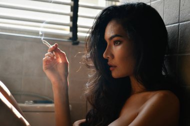 Sigara kavramı. Seksi kadın odaya sigara içiyorsun. Seksi kadın sigara tarafından rahatlatıcı. Güzel kadınlar baştan çıkarıcı cazibesi var.
