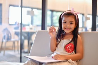 Eğitim kavramları. Kız kütüphanede ders çalışıyor. Güzel kız mutlu öğrenme vardır.