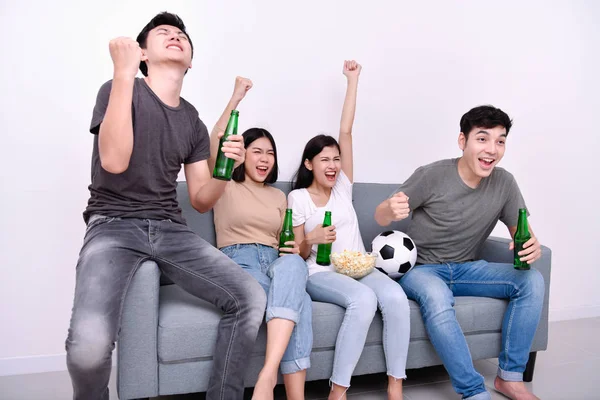 Concept of cheering. Asian teenagers watching football on television. People are cheering and winning football scores.