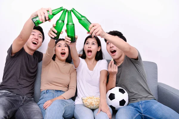 Concept of cheering. Asian teenagers watching football on television. People are cheering and winning football scores.