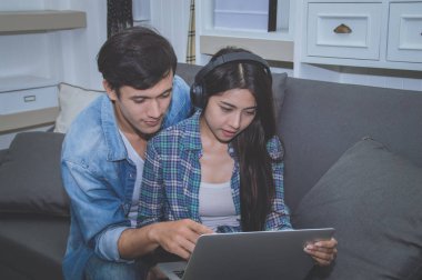 Çiftler kavramı. Aşık oturma odasında oynuyorlar. Çiftler Internet üzerinden alışveriş vardır. Aşık bir defter mutlu oynuyorlar. Oturma odasında rahatlatıcı aşıklar.