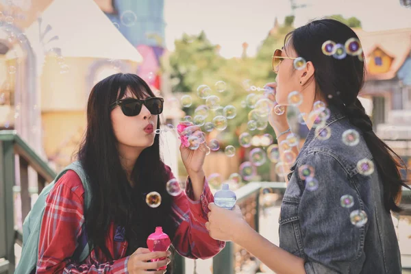 Travel Concepts. Beautiful girl is playing soap bubble fun. Asian girls are relaxing travels. Asian girls blowing bubbles into the air. Beautiful girl takes a break in playing bubble activities.