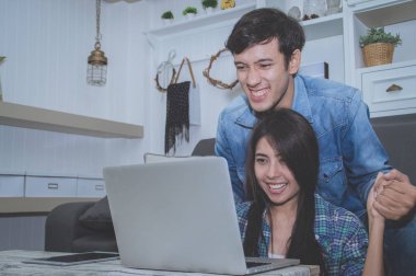 Çiftler kavramı. Aşık oturma odasında oynuyorlar. Çiftler Internet üzerinden alışveriş vardır. Aşık bir defter mutlu oynuyorlar. Oturma odasında rahatlatıcı aşıklar.