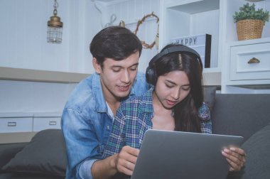 Çiftler kavramı. Aşık oturma odasında oynuyorlar. Çiftler Internet üzerinden alışveriş vardır. Aşık bir defter mutlu oynuyorlar. Oturma odasında rahatlatıcı aşıklar.