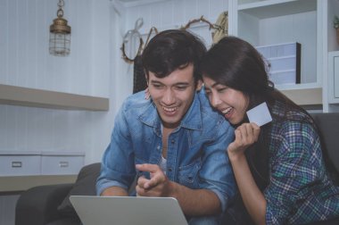 Çiftler kavramı. Aşık oturma odasında oynuyorlar. Çiftler Internet üzerinden alışveriş vardır. Aşık bir defter mutlu oynuyorlar. Oturma odasında rahatlatıcı aşıklar.