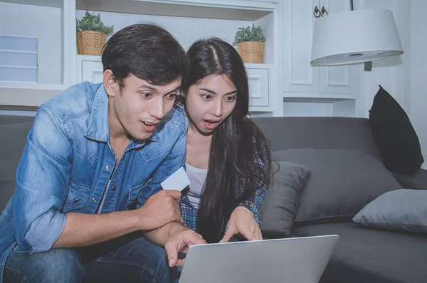 Çiftler kavramı. Aşık oturma odasında oynuyorlar. Çiftler Internet üzerinden alışveriş vardır. Aşık bir defter mutlu oynuyorlar. Oturma odasında rahatlatıcı aşıklar.