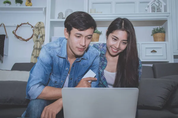 Çiftler kavramı. Aşık oturma odasında oynuyorlar. Çiftler Internet üzerinden alışveriş vardır. Aşık bir defter mutlu oynuyorlar. Oturma odasında rahatlatıcı aşıklar.