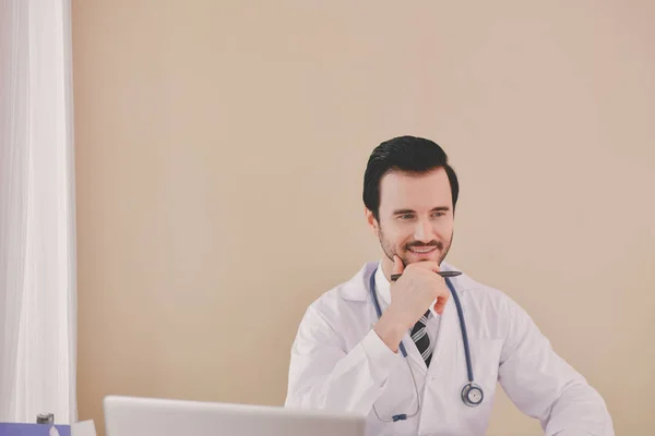微笑的医生摆在办公室 他戴着听诊器 医务人员在医院的背景 — 图库照片