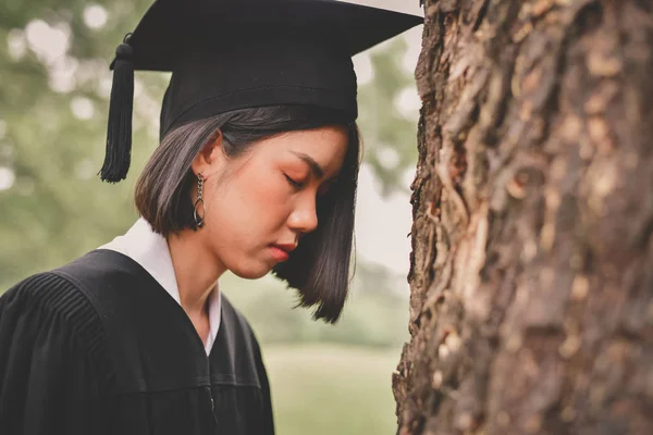 Graduation Concept. Graduated students on graduation day. Asian students are smiling happily on the graduation day. Students wear graduation gowns in the garden