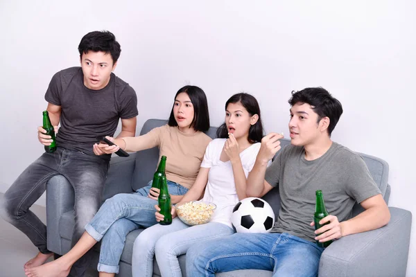 Concept of cheering. Asian teenagers watching football on television. People are cheering and winning football scores.