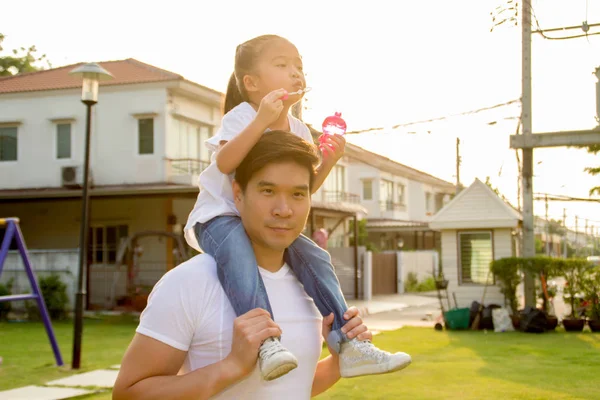 Father took his daughter riding on the neck in the park.