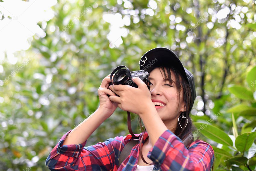 Travel concept. Asian girls are traveling in the woods.  Beautiful women are taking photos in the forest.
