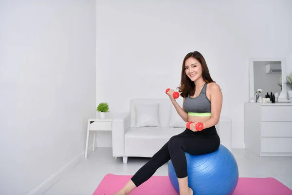 Concept of exercise. Beautiful girl is exercising in her house. Beautiful girl takes good care of her health.