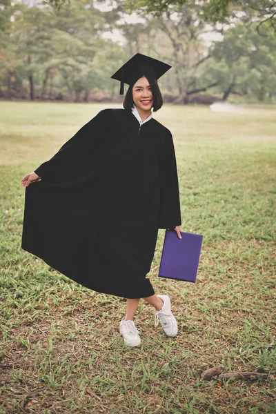 卒業の概念 卒業式の日に卒業生 アジアの学生は 卒業式の日幸せそうに笑っています 学生は庭で卒業ガウンを着用します — ストック写真