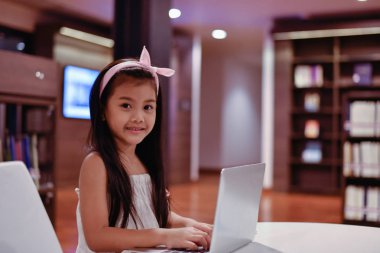 Eğitim kavramları. Kız kütüphanede ders çalışıyor. Güzel kız mutlu öğrenme vardır.