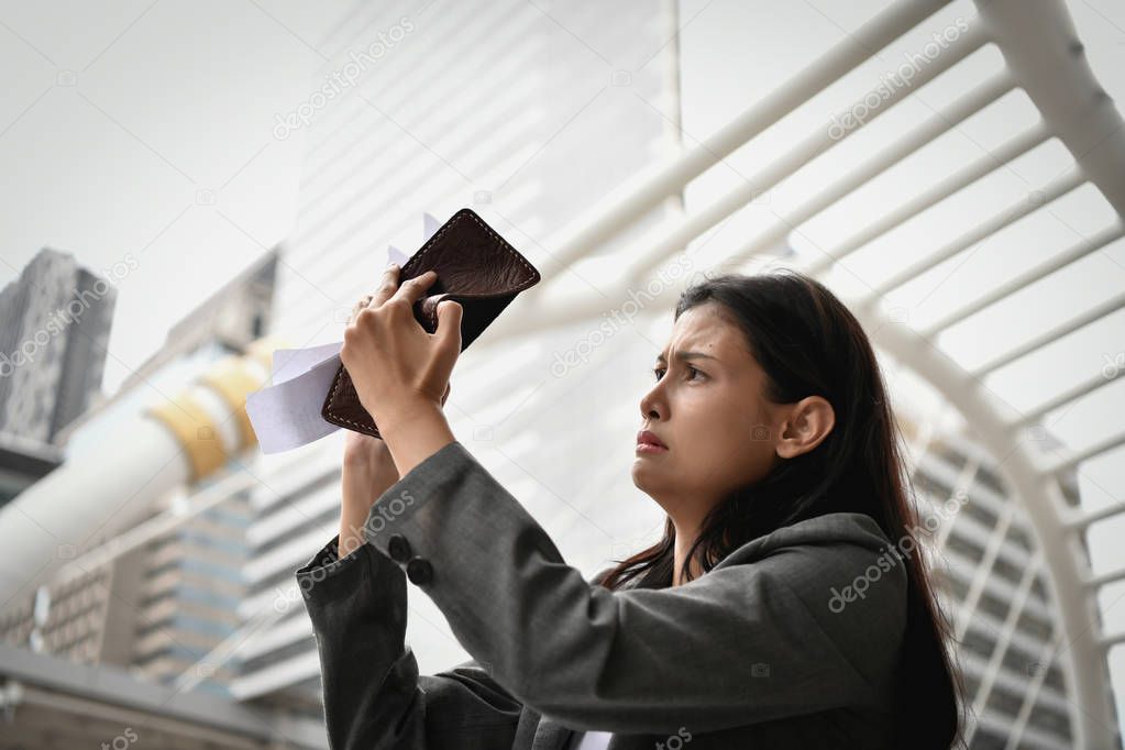 Concept of unemployed. Young business woman is stressed because of no money. Young businesswoman looking at the bill of credit.