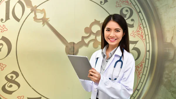 Smiling doctor posing in the office, She is wearing a stethoscope, medical staff on the hospital background