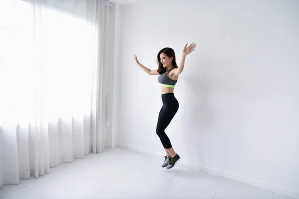 Concept of exercise. Beautiful girl is exercising in her house. Beautiful girl takes good care of her health.