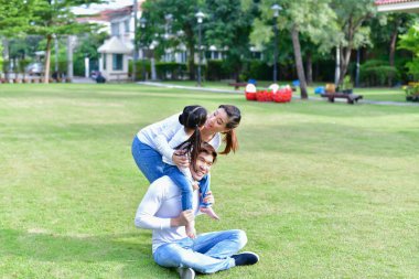 Aile kavramı. Aile Bahçesi mutlu aktiviteler yapıyor. Ebeveynlerin çocukları ile bahçede oynuyorlar.