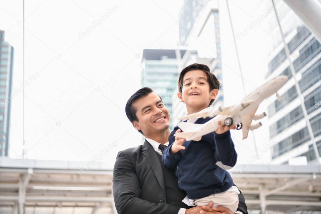 Family concept. Dad and son are playing fun toys. A businessman is carrying his son inside the city.