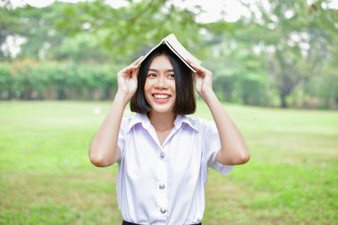 Eğitim kavramları. Güzel öğrenci parkta kitap okuma. Güzel kız parkta rahatlatıcı. Genç öğrenci okumak mutlu. Çalışmaya genç öğrenci aşk. Asyalı kadınların eğitim.