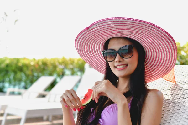 Mayo kavramı. Güzel kız pembe mayo giyiyor. Güzel mayo yüzme havuzunda rahatlatıcı kızıdır. Güzel kız lezzetli ile karpuz yiyor.