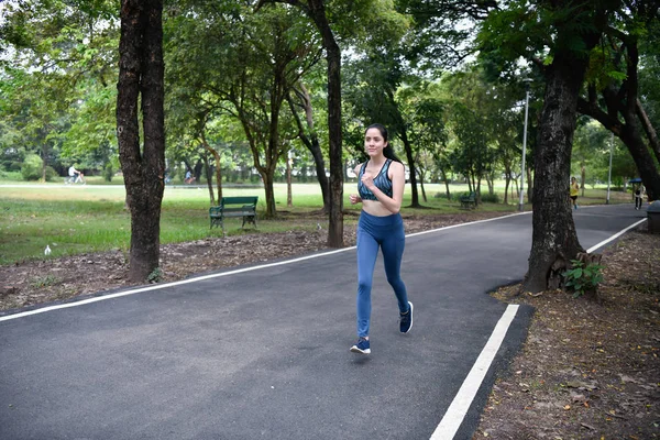 Exercise concept. Athletic girl exercising within the park. Beautiful girl jogging in the morning.