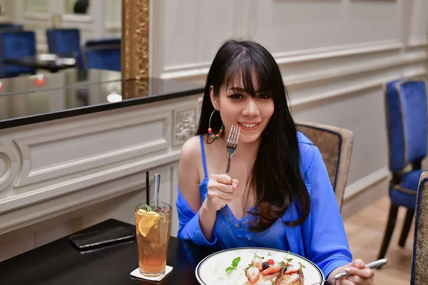 Restaurant Concept. Asian women eating in restaurant. Asian women are happy to eat. Asian women relax in a restaurant. Asian women are smiling happily.
