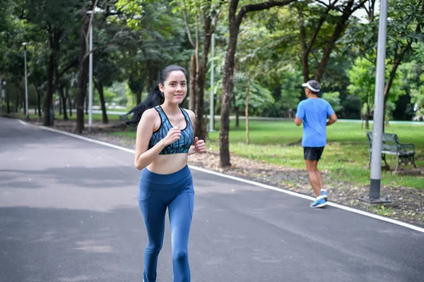 Exercise concept. Athletic girl exercising within the park. Beautiful girl jogging in the morning.