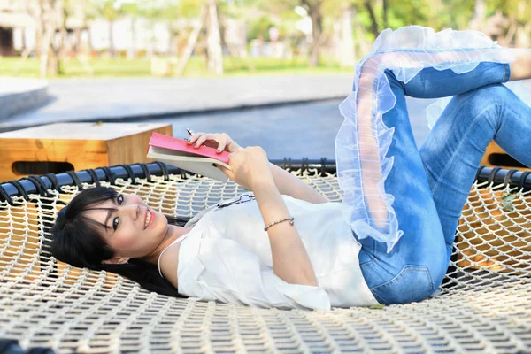 教育理念 亚洲妇女在公园看书 美丽的女人在公园里放松 美丽的女人是快乐的阅读 — 图库照片