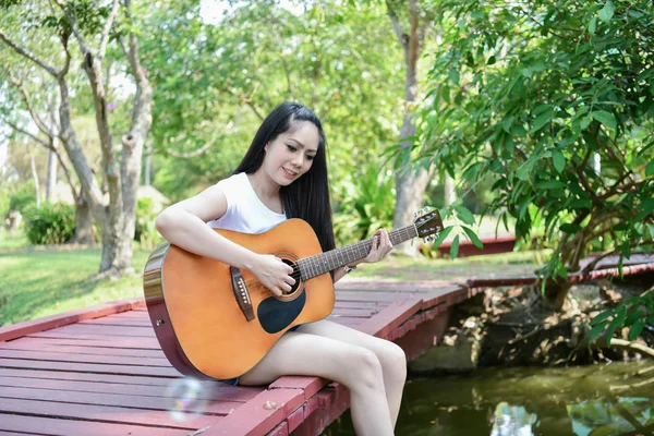 개념입니다 아시아 여자는 기타를 연주입니다 아시아 음악과 휴식입니다 아시아 여자는 — 스톡 사진