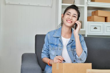 KOBİ iş kavramı. Asya Gençler onların paketleri yüklüyorsunuz. Genç insanlar telefon ile iletişim.