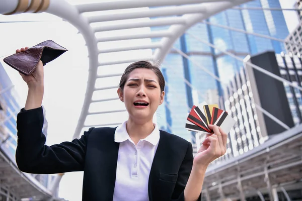 Concept of unemployed. Asian businesswoman is opening empty wallet. Young business woman is stressed because of no money.