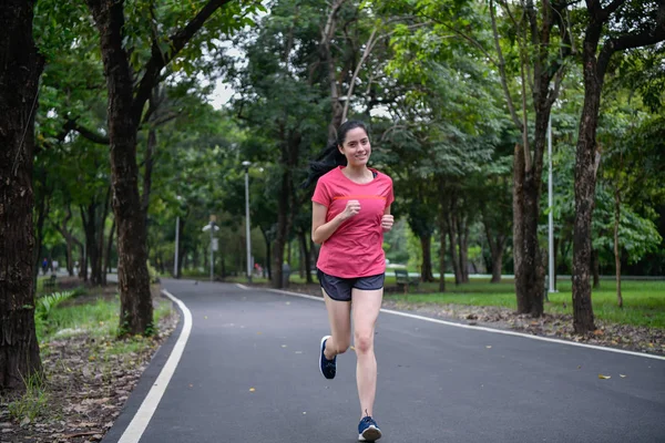 Exercise concept. Athletic girl exercising within the park. Beautiful girl jogging in the morning.
