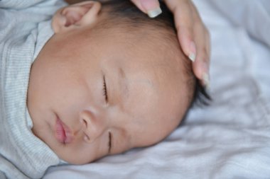 Yeni doğan kavramı. Anne ve çocuk beyaz bir yatakta. Anne ve bebek çocuk yatak odasında oynarken. Ebeveyn ve çocuk evde rahatlatıcı. Aile birlikte eğleniyor. Yeni doğan bebek Füssing ve ağlıyor.