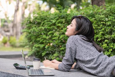 Tatil kavramı. Genç bir işadamı bahçede çalışıyor. B