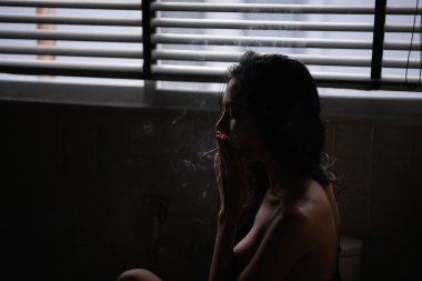 Seksi konsept. Şehvetli kadınlar tuvalette sigara emme