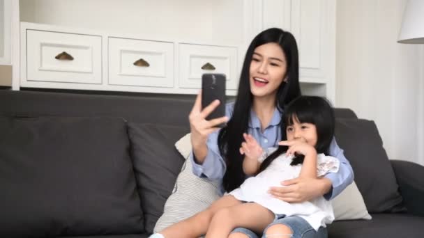 Family concept. Mom is inviting her daughter to take pictures in the living room. — Stock Video