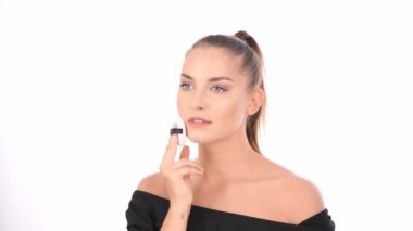 Güzellik konsepti. Genç kadın toz puf ile yüzüne blusher uygulayarak.