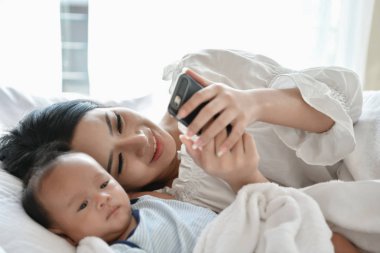 Yeni doğan kavramı. Anne ve çocuk beyaz bir yatakta. Anne ve bebek b