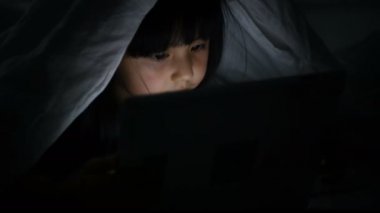 İletişim kavramı. Kız yatmadan önce tablet oynuyor..