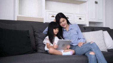 Aile konsepti. Anne ve kızı evde birlikte oyun oynuyorlar..