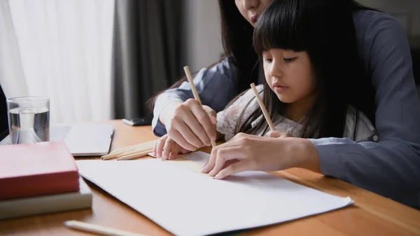 Concept de famille. Maman enseigne aux enfants à dessiner des images . — Photo