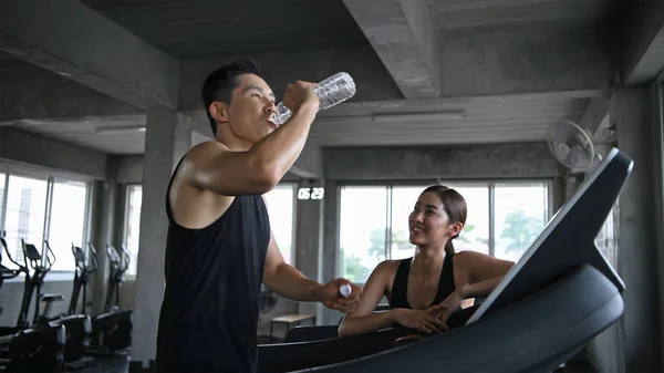 Exercise concept. The young woman is delivering drinking water t