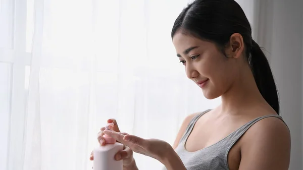 Il concetto di bellezza. Ragazze asiatiche stanno applicando la crema per la pelle nella stanza . — Foto Stock