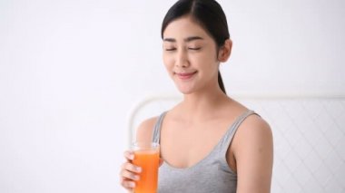 Sağlık konsepti. Asyalı kadınlar lezzetli meyve suları içiyor.