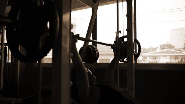 Egzersiz konsepti. Genç adamın gölgesi ağırlığı kaldırıyor.